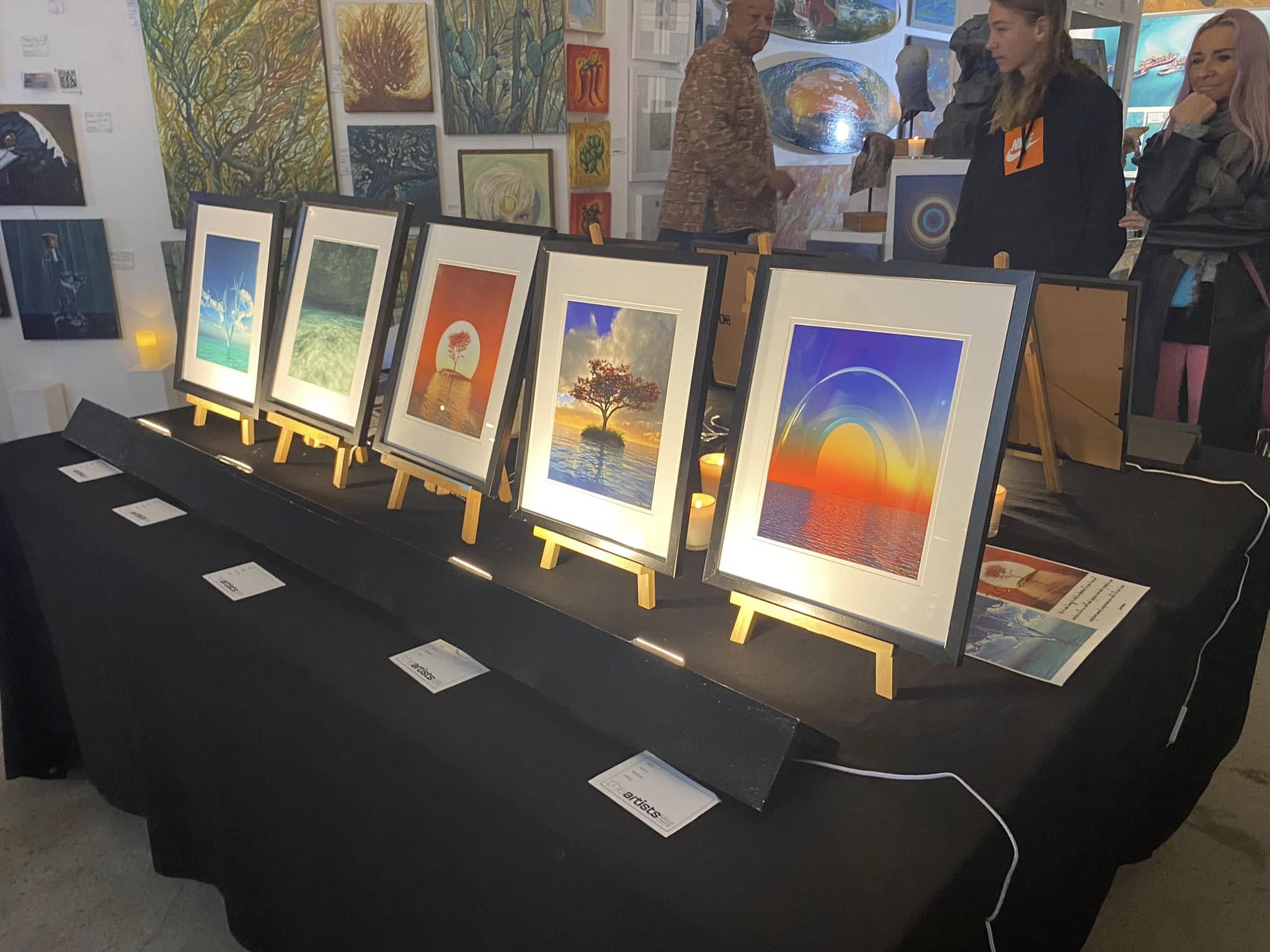 A row of Jay Salton's framed digital artworks displayed on easels in a Gold Coast gallery